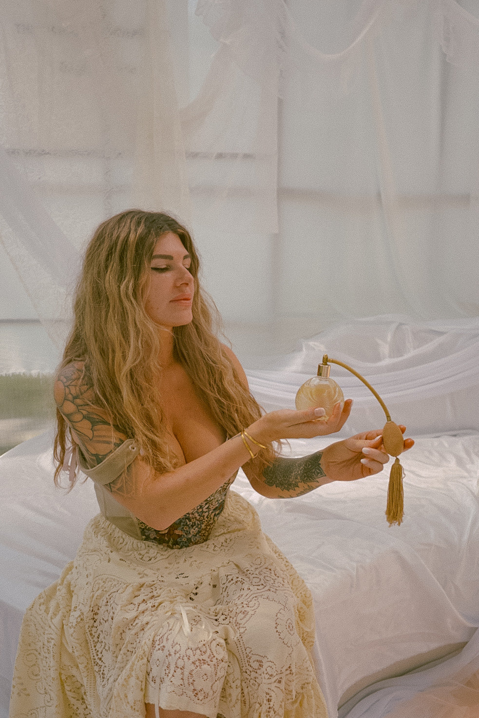Woman holding a perfume bottle in a softly lit room