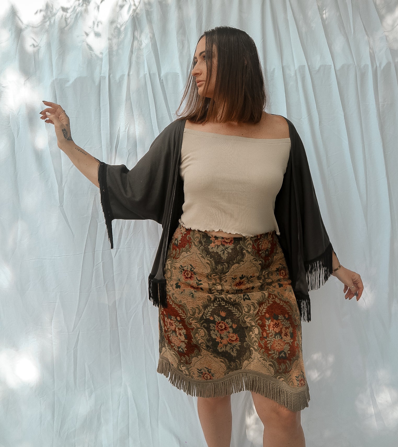 woman wearing charcoal cardigan with sand shirt and floral skirt