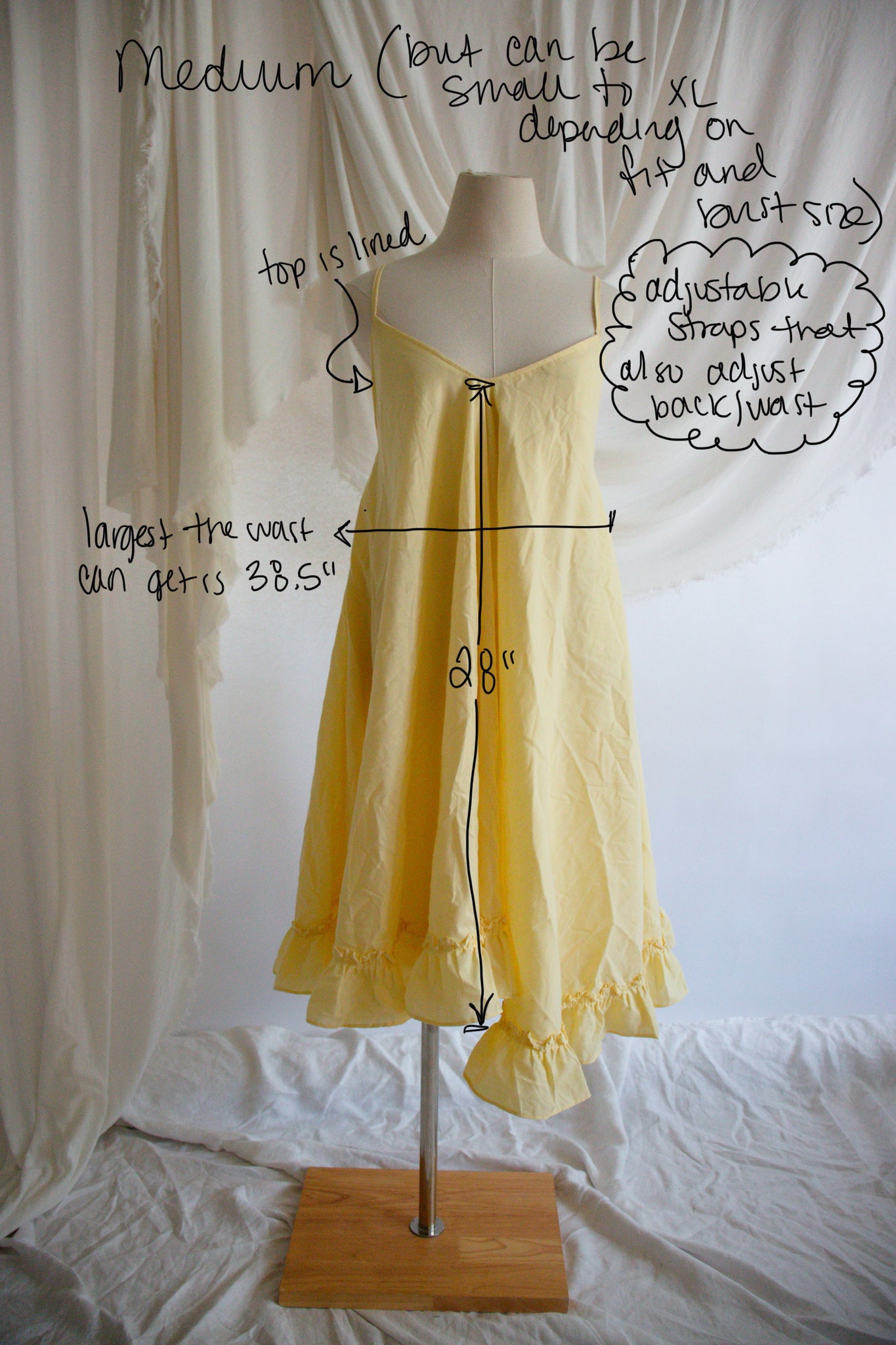 Yellow dress on a mannequin with measurements and notes on a white background
