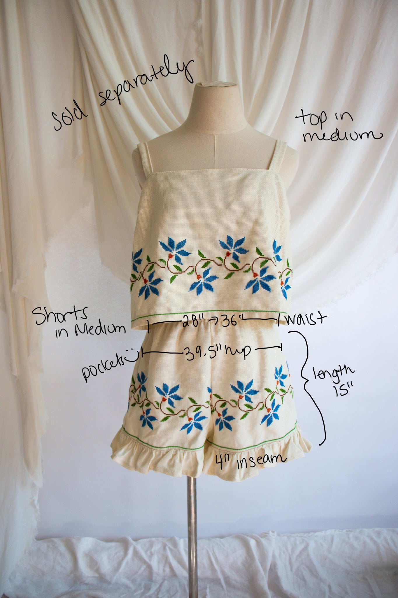 Mannequin wearing a dress with floral patterns and measurements on a white background