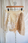 Skirt lace detailing on a hanger against a white curtain background
