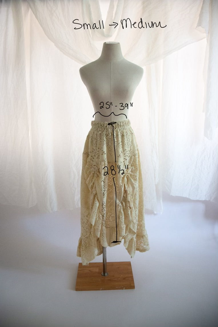 Mannequin wearing a lace skirt with measurements on a white background