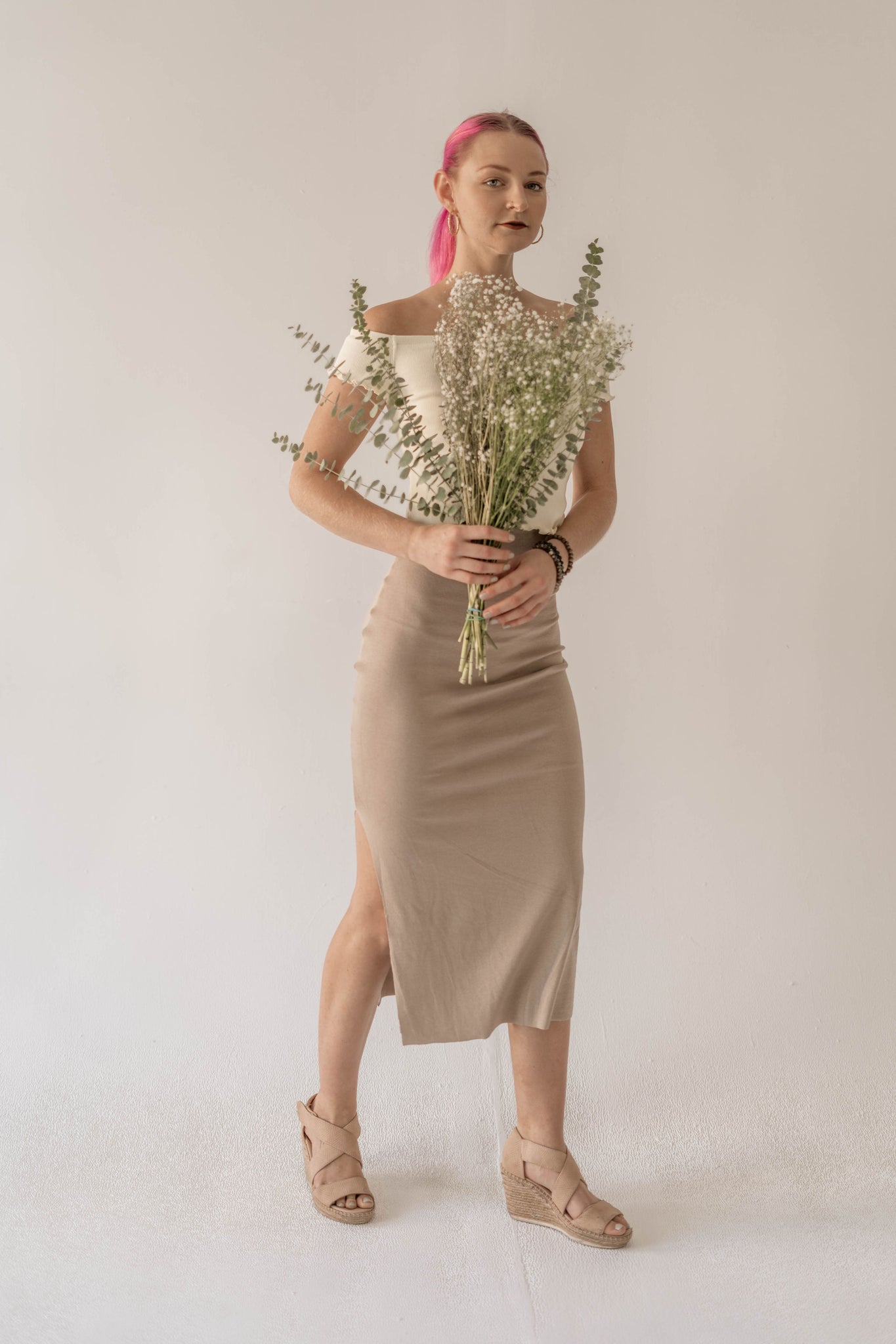woman wearing skirt holding flowers